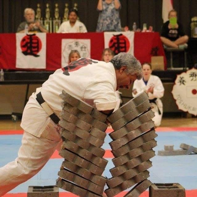 Sensei Jose Cruz breaking a stack of concrete blocks at a tournament demonstration